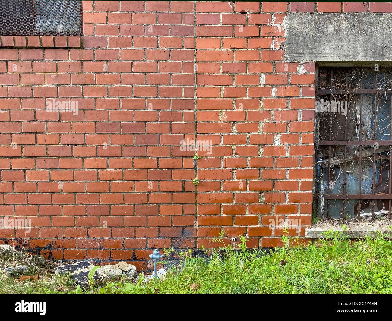 a pair of iron gate windows on an old brick warehouse building Stock Photo
