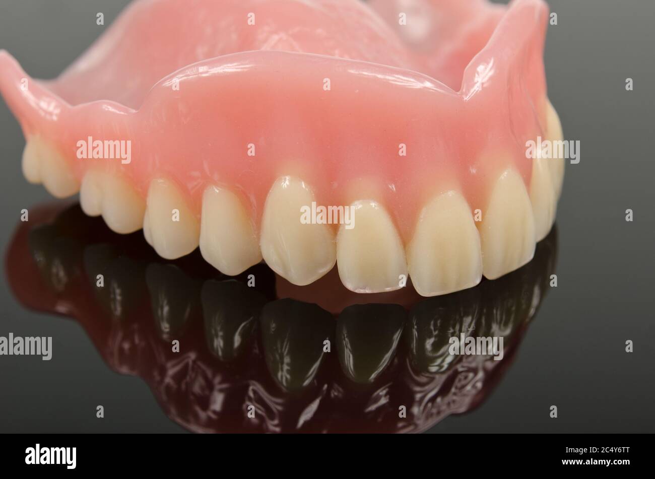 denture, upper jaw placed on a reflective surface Stock Photo