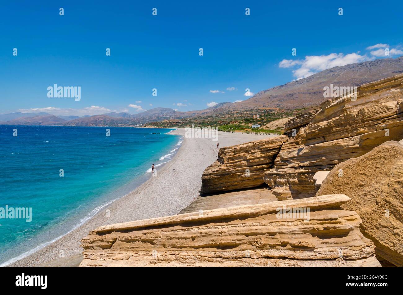 The long sandy beach of Triopetra in south Crete.The beach is named after the three rocks in the sea. Stock Photo