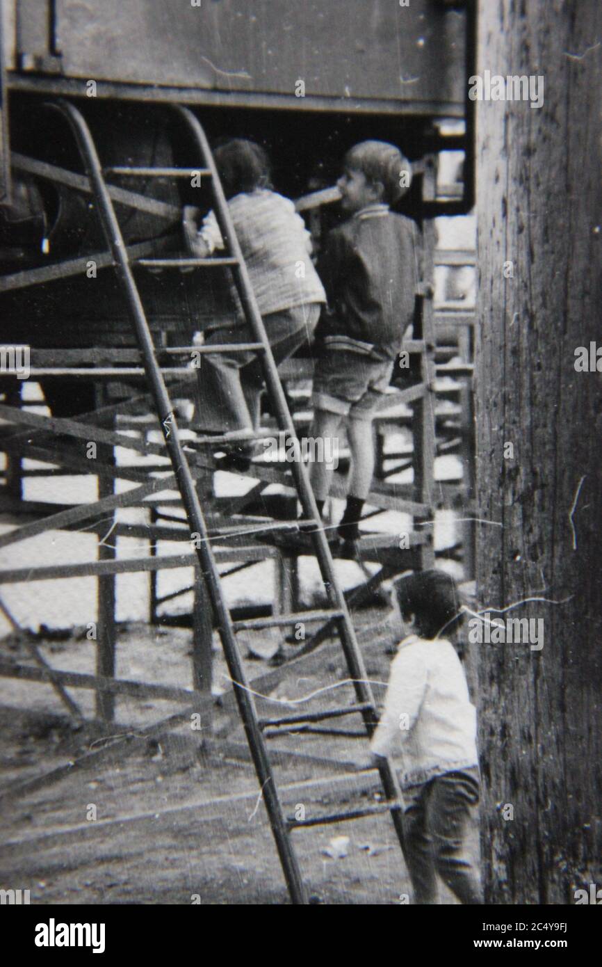 Fine 70s vintage black and white photography of kids playing on the playground equipment Stock