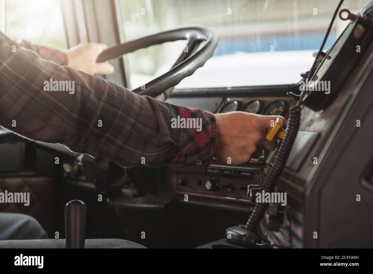 Semi Truck Male Driver Inside Of Vehicle Behind Steering Wheel. Transportation Industry Concept. Stock Photo