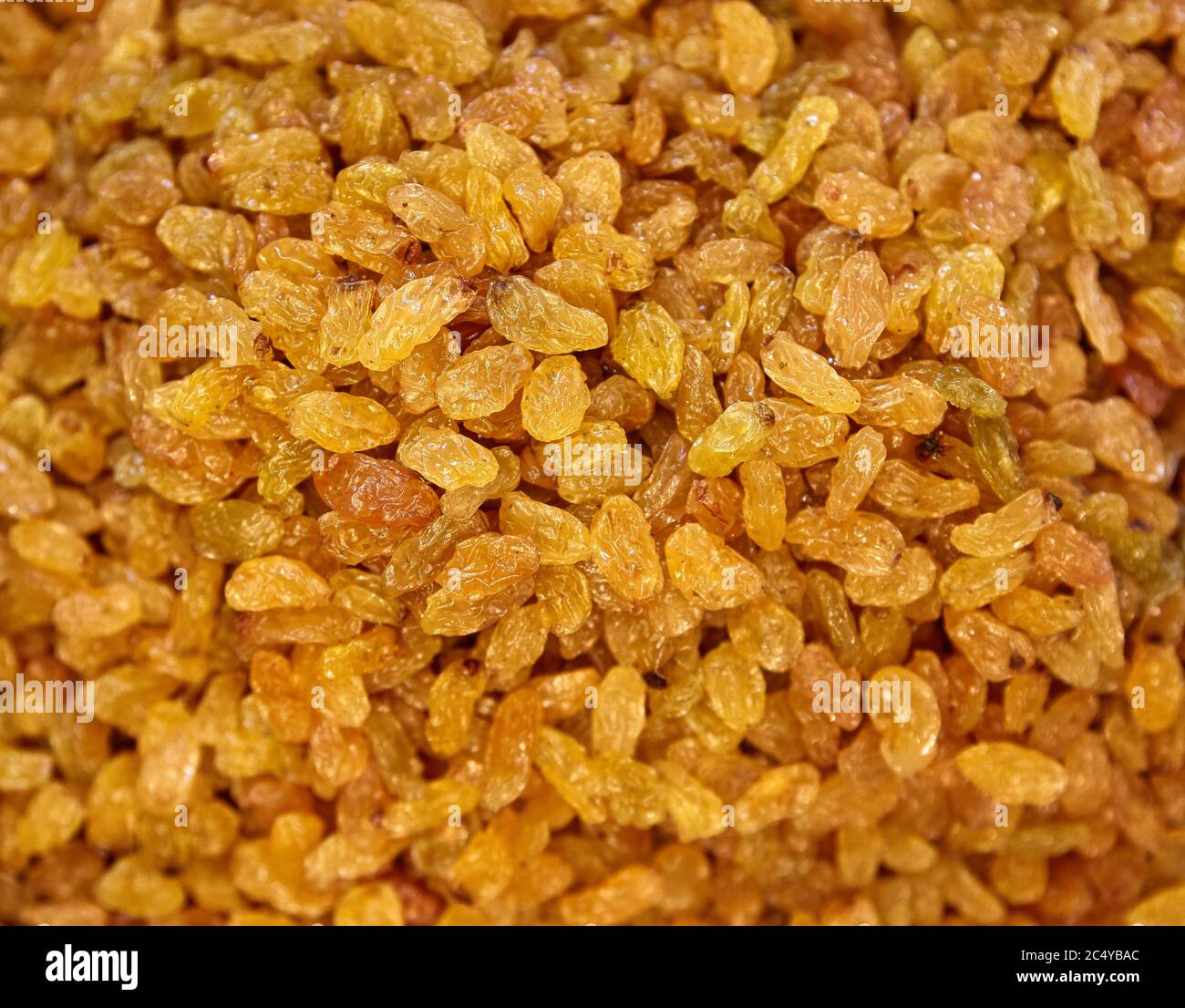 Raisins Background. Yellow Sultanas. Golden Dried Seedless Grapes Top View. Stock Photo