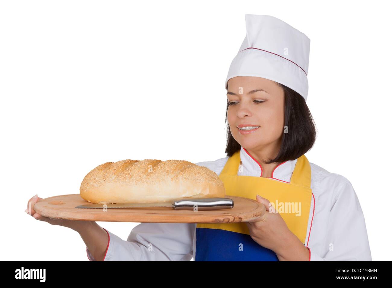 A baker woman holds fresh bread in her hand against the background of bakers  working in a bakery Stock Photo - Alamy