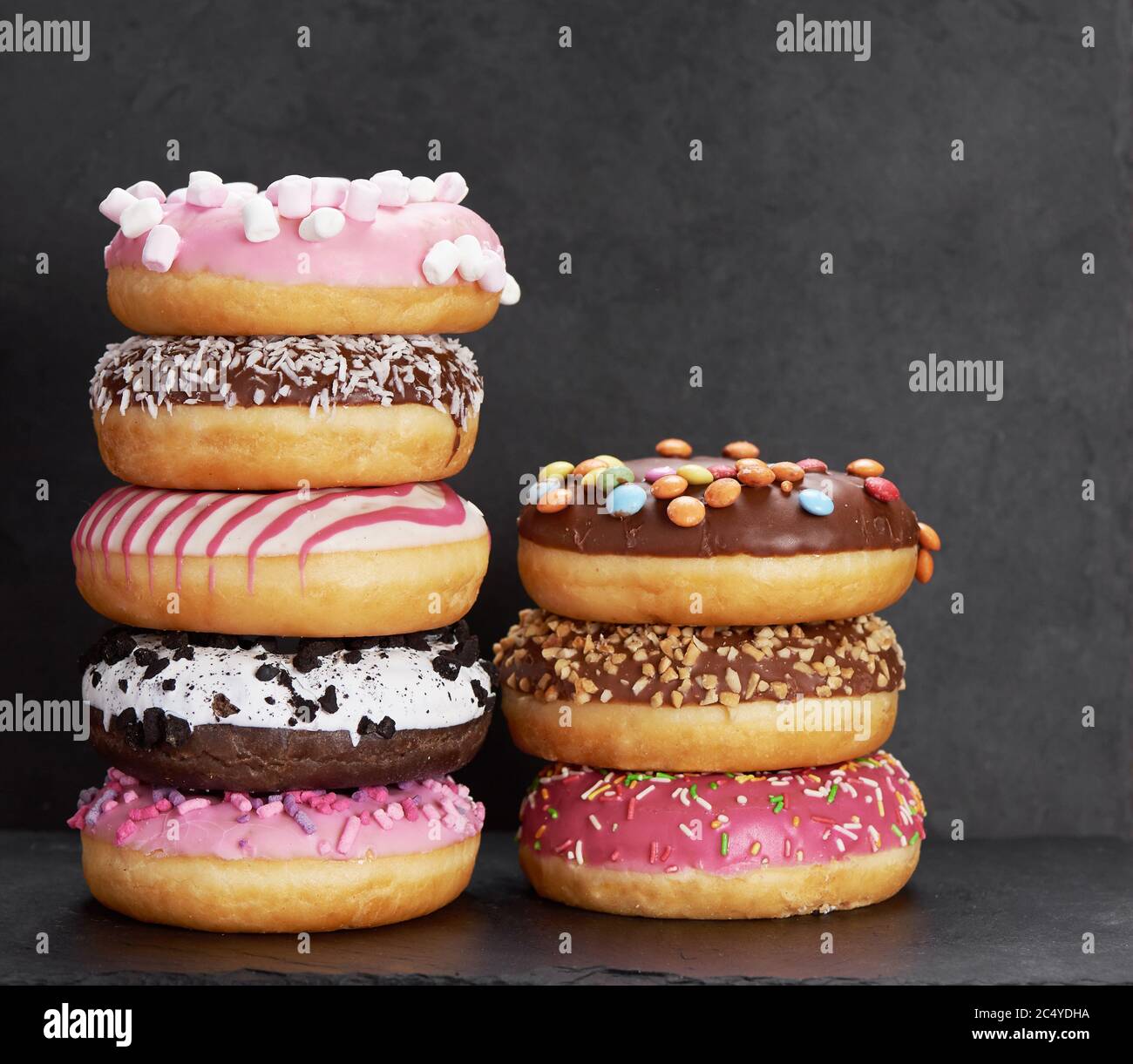 Stack of colorful donuts on a stone background Stock Photo