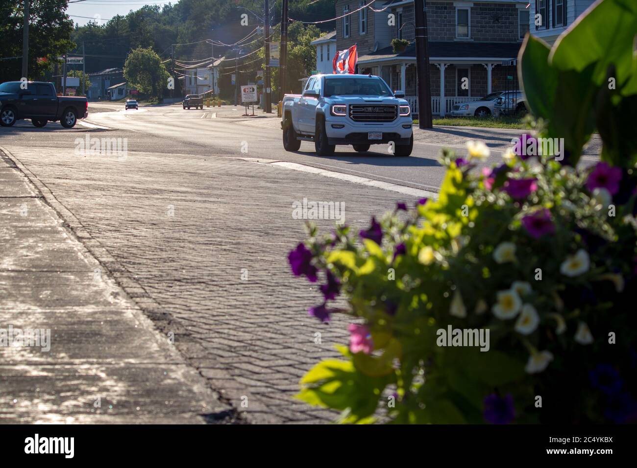 Barry's Bay, Ontario, Canada June 29, 2020 - Sunny Downtown Barry's Bay with white truck driving by that has Canada flag on it. Stock Photo