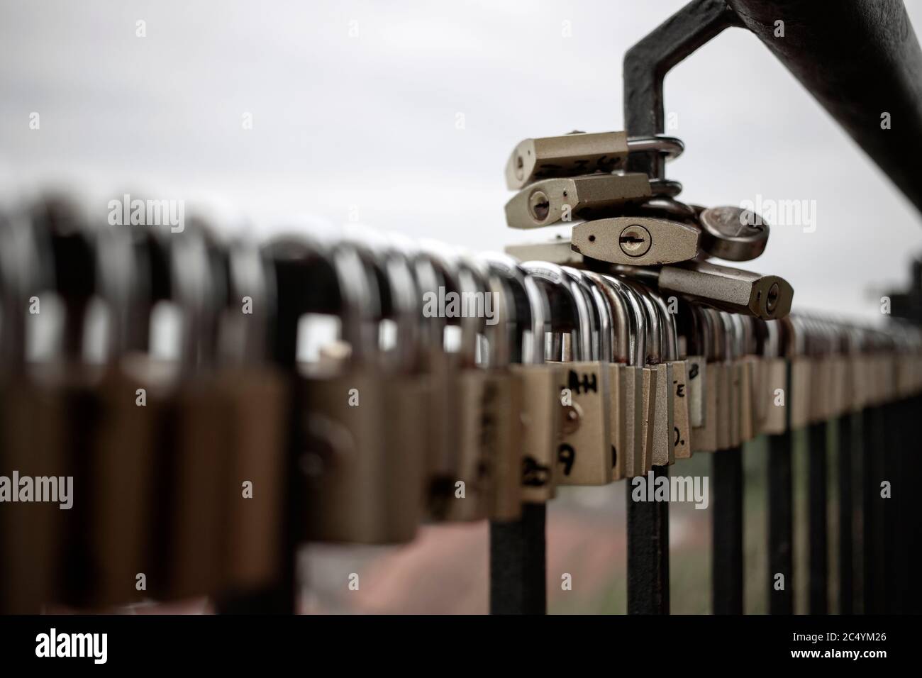 A large number of padlocks attached to the fence Stock Photo