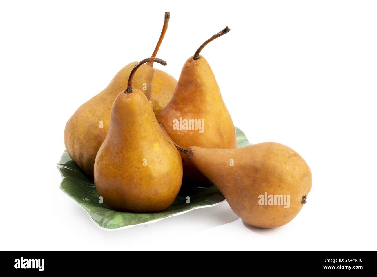 a group of Bosc pears on a green leaf shaped plate isolated on white Stock Photo