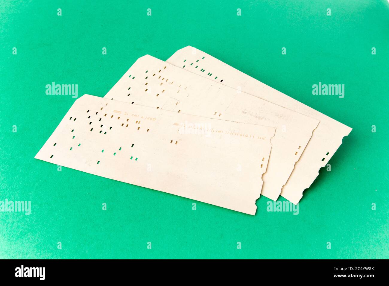 computer history - 80 column computer keypunch cards on a green background Stock Photo