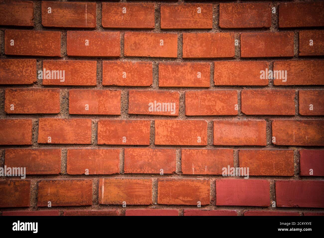 Detail of red brick wall background with dark vignette in corners Stock Photo