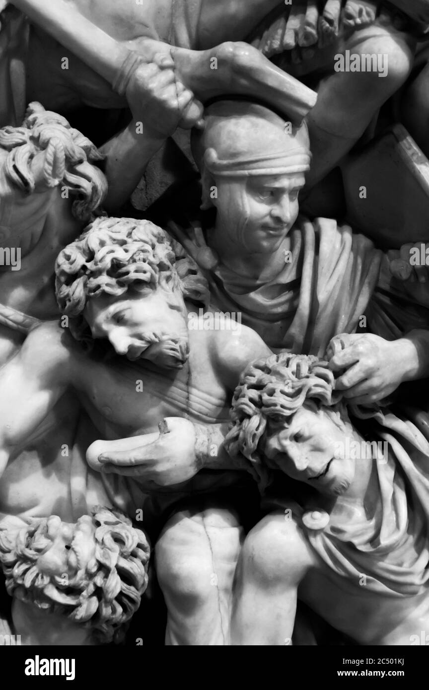 Black and white photo showing detail of large marble sculpture of an battle scene in ancient Rome Stock Photo