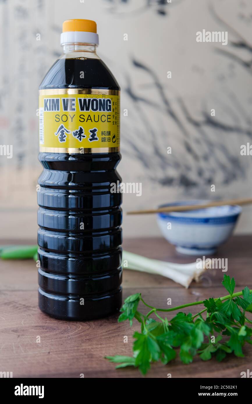 A bottle of Kim Ve Wong brand naturally brewed soy sauce on a kitchen top with parsley and spring onions. Stock Photo