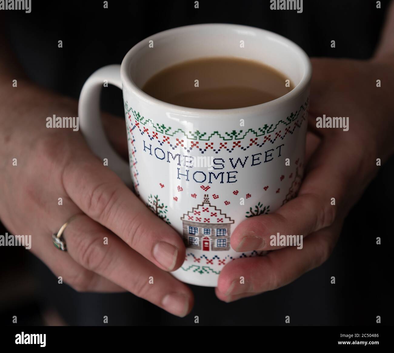A woman's hand holding a mug of milk tea. Stock Photo