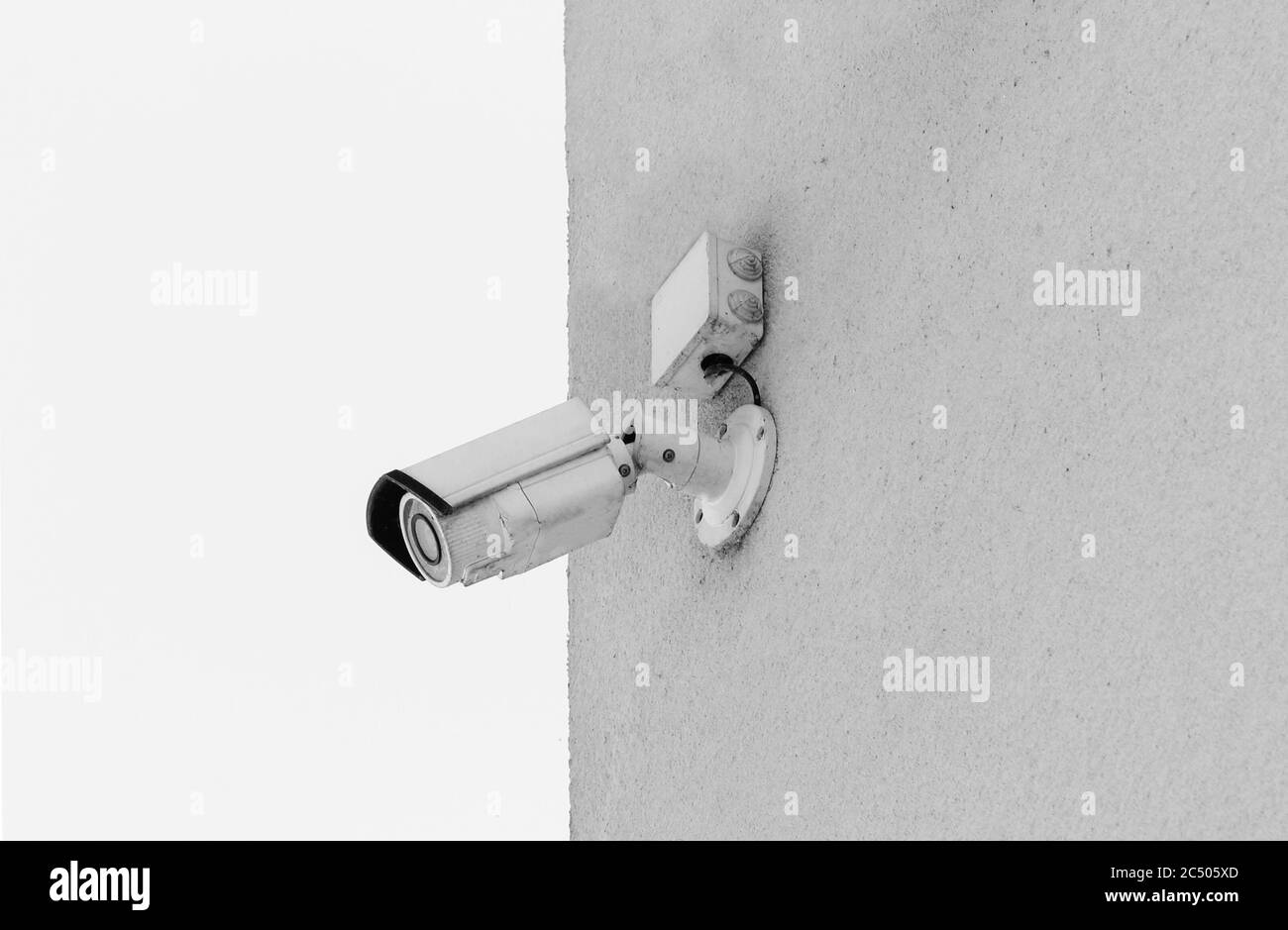 Surveillance camera mounted to wall in black and white. CCTV camera