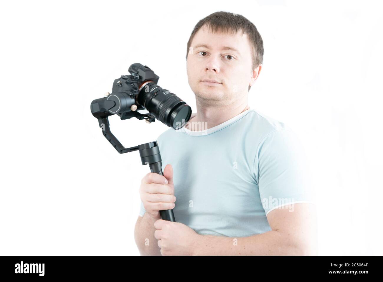 The guy holds a 3-axis stabilizer with a camera in his hand, takes a selfie video. Stock Photo