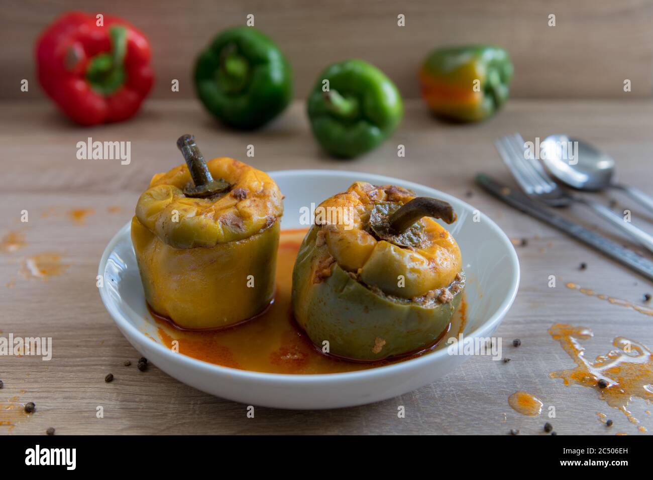 Two stuffed bell peppers served in a bow with delicious sauce. Stock Photo