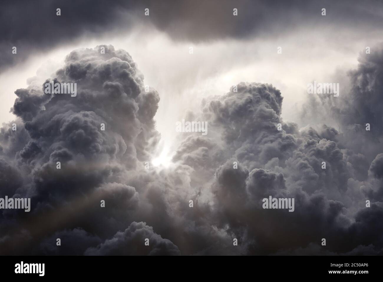 Sun rays breaking through the dark clouds. Clouds background. Dramatic grey clouds Stock Photo