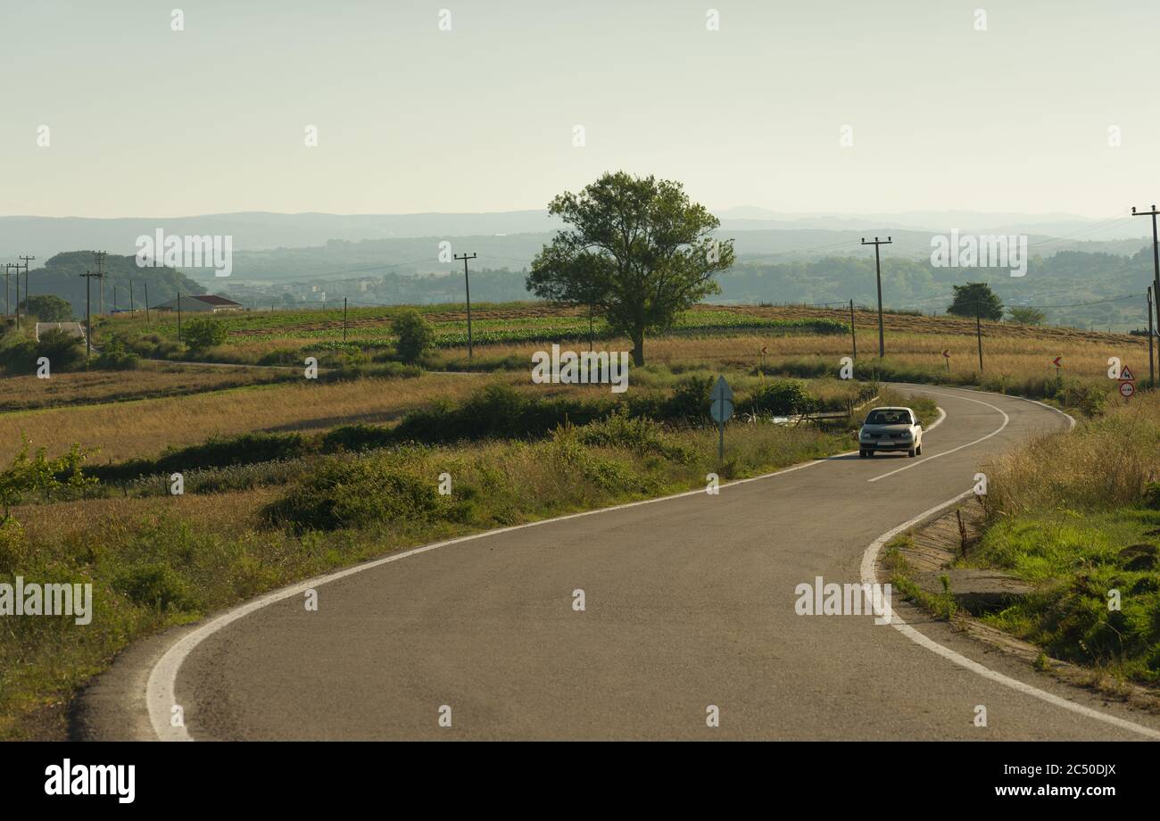 Transportation background. Car going on curvy village road Stock Photo -  Alamy