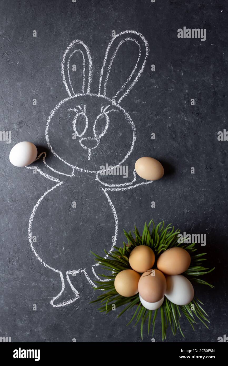 Easter bunny with eggs. Green grass and eggs. Chalk drawn bunny with real grass and eggs. Stock Photo