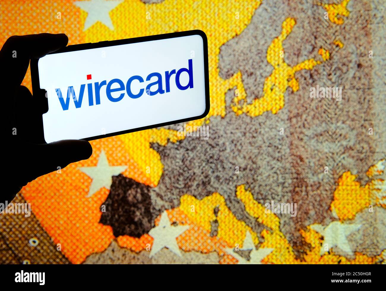 Stone /United Kingdom - June 29 2020: Wirecard logo on smartphone and euro banknote large image on the blurred background screen. Real photo, not a mo Stock Photo