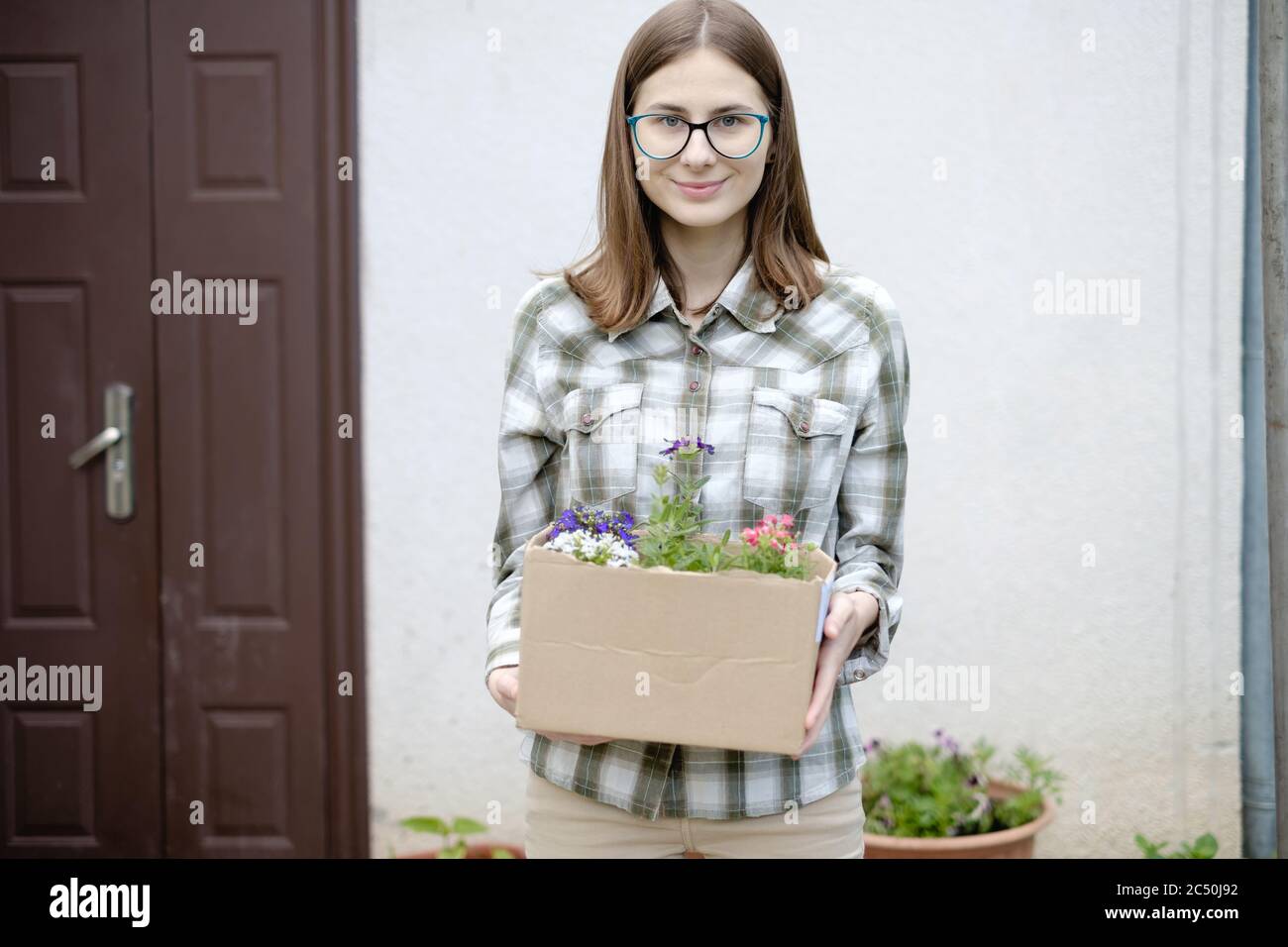 Woman Holding A Box Of Flowers To Plant Them In A Flower Bed Stock Woman Holding A Box Of Flowers To Plant Them In A Flower Bed Stock