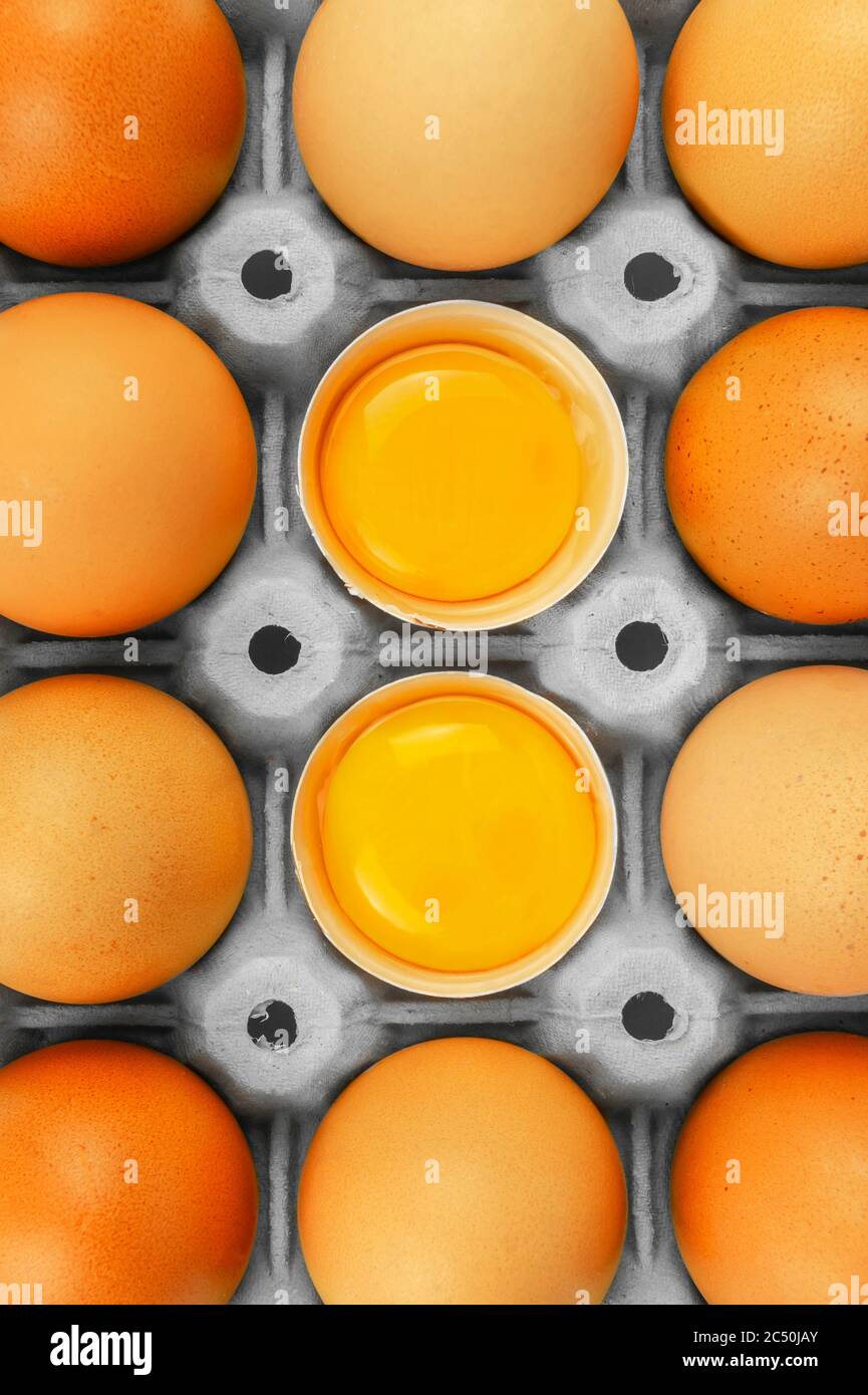Brown chicken eggs package box with 2 opened and visible egg yolks in grey pack Stock Photo Alamy