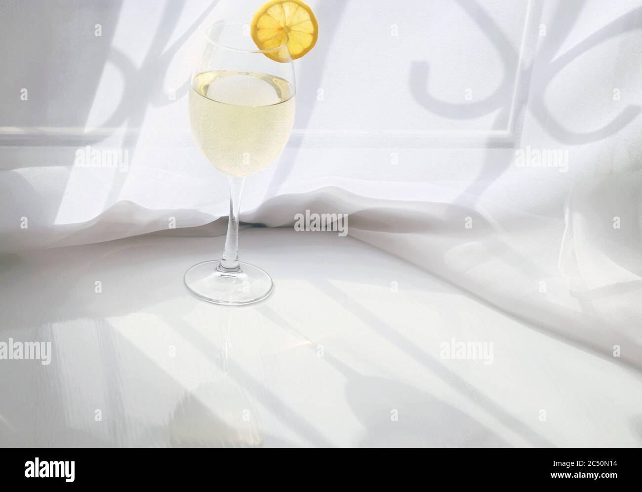 Limoncello or white wine in transparent long glass Stock Photo