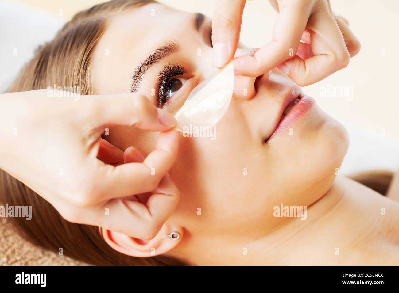 Skin care under the eyes, patches are applied to the young woman's eyes