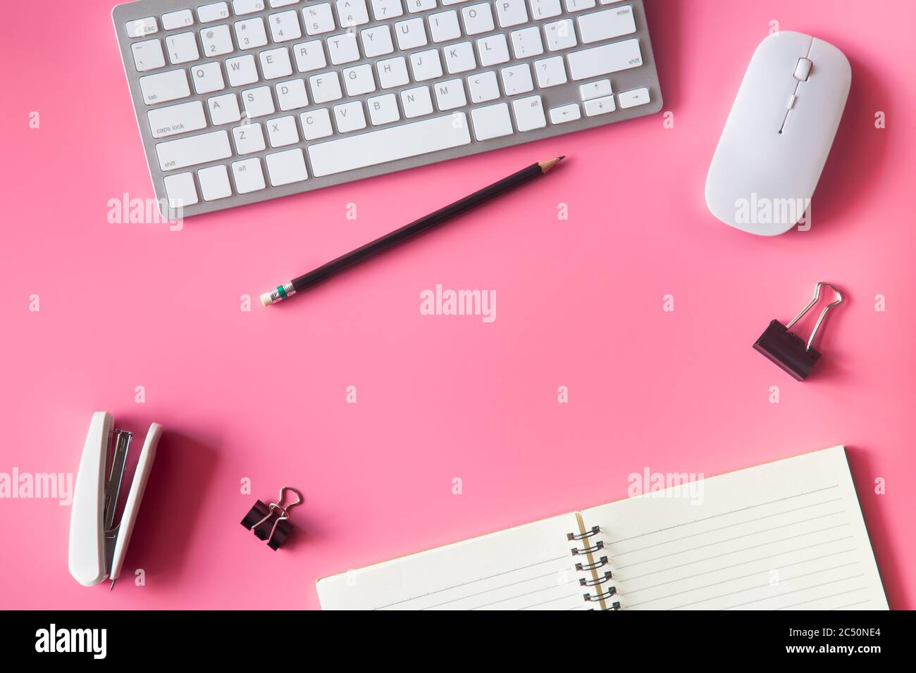 Pastel pink desk office with laptop, smartphone and other work supplies