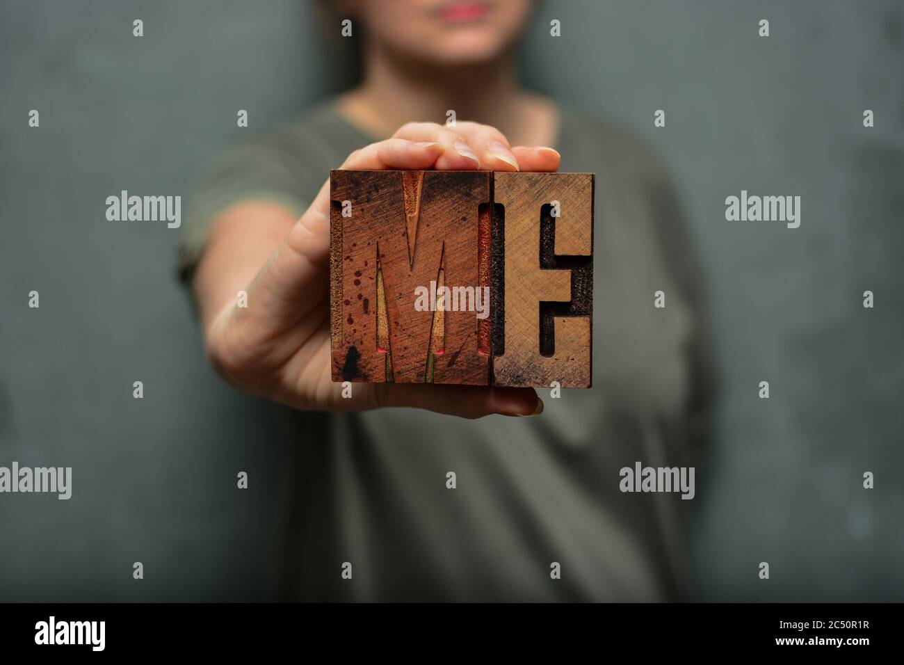 Woman holding the word 'me' made of wooden typographic letters. Emancipation, personality, human rights, LGBT, feminism, self-confidence concept Stock Photo