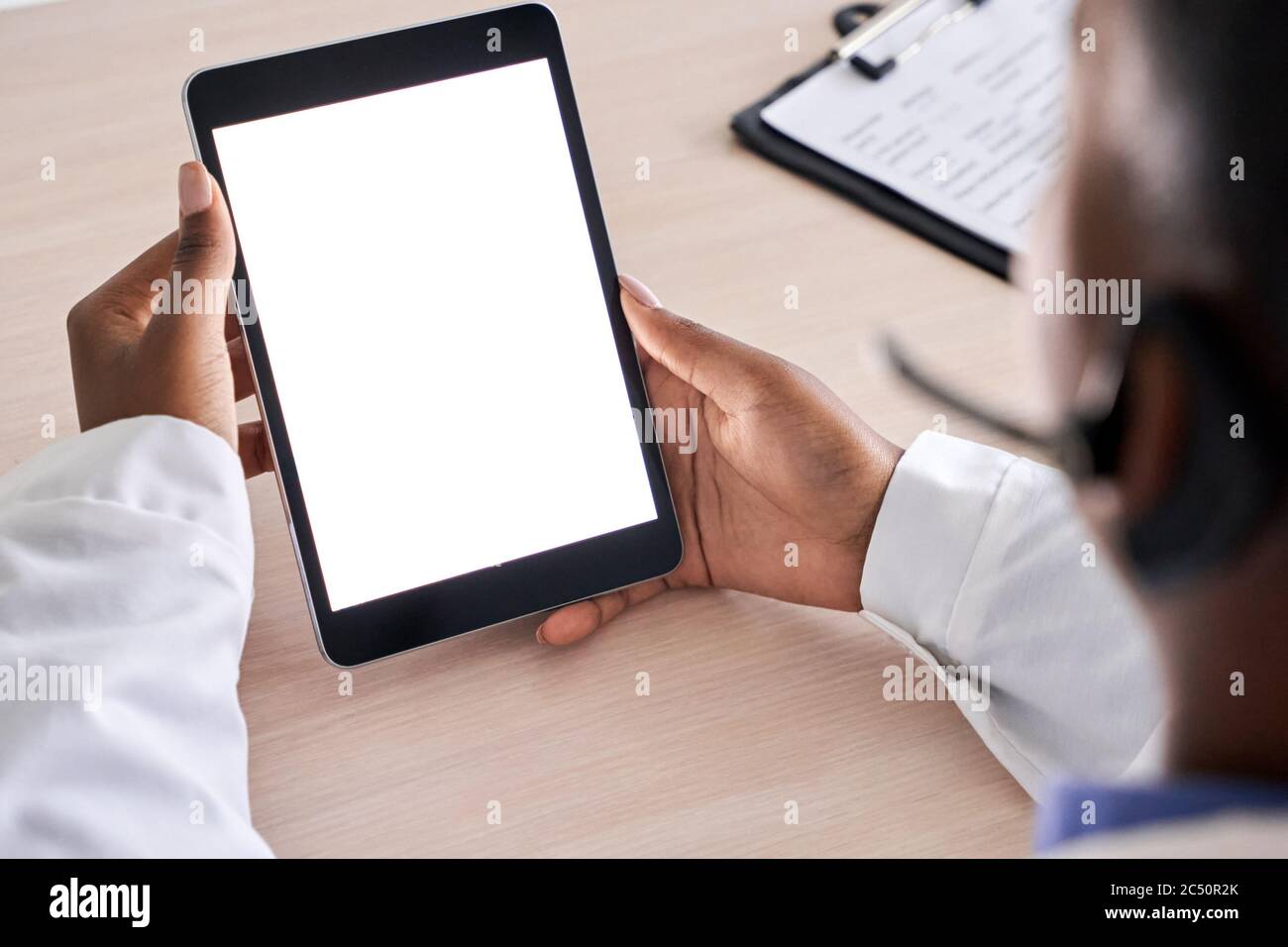 African doctor holding using digital tabelt mock up white screen, close up. Stock Photo