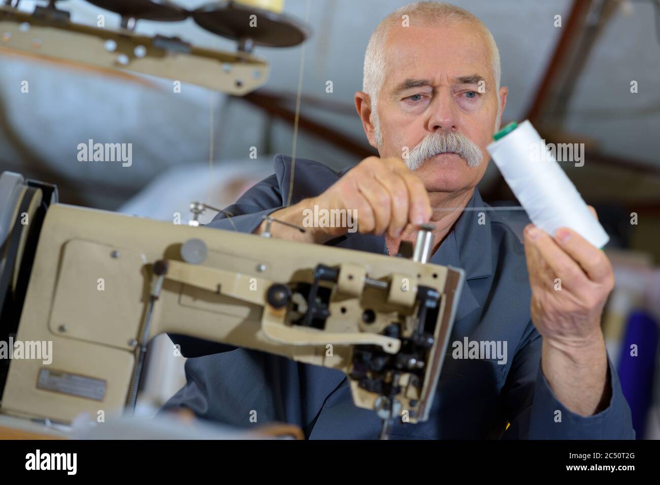 senior man threading up an industrial sewing machine Stock Photo Alamy