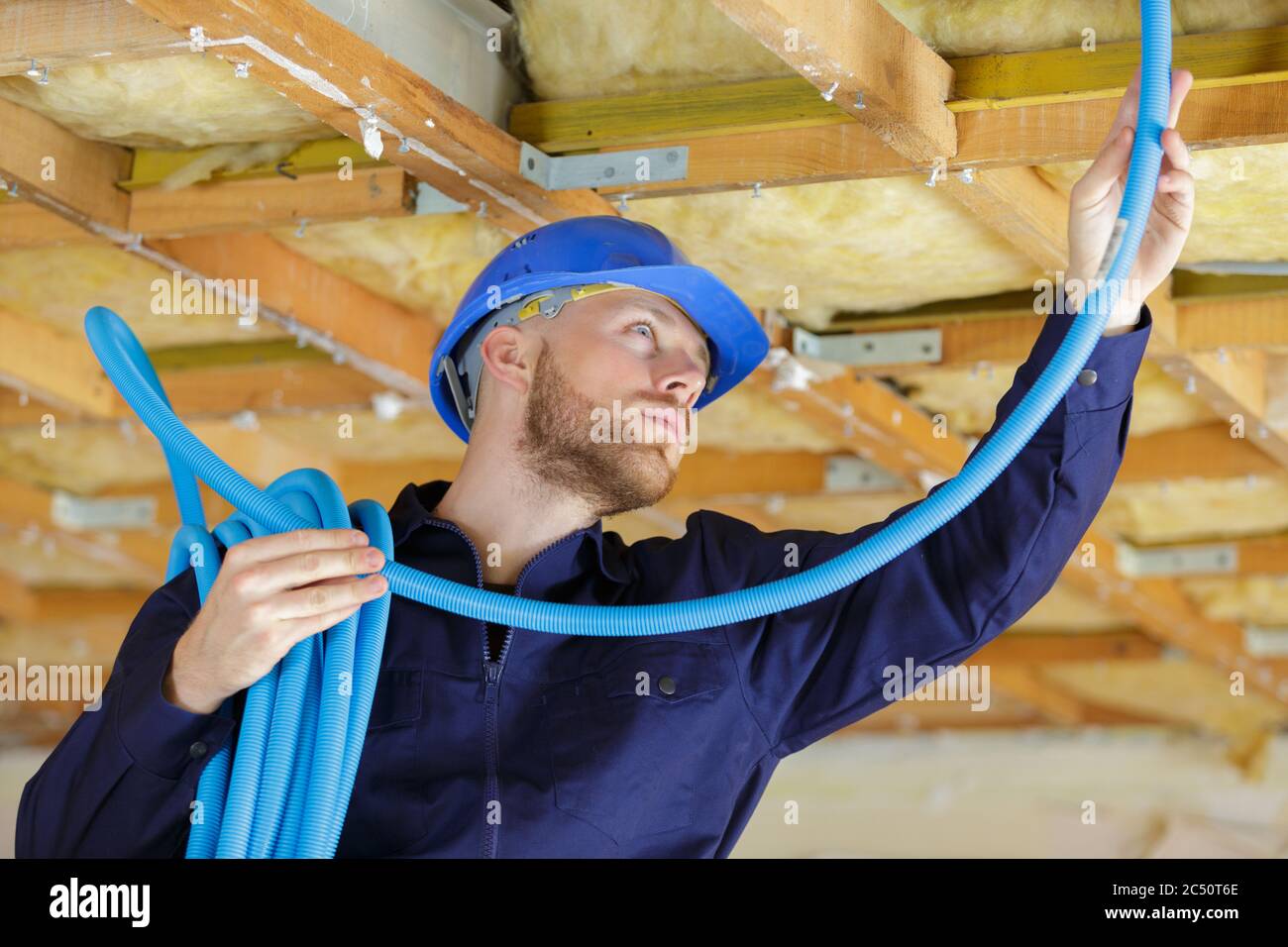 a plumber checking ceiling pipes Stock Photo
