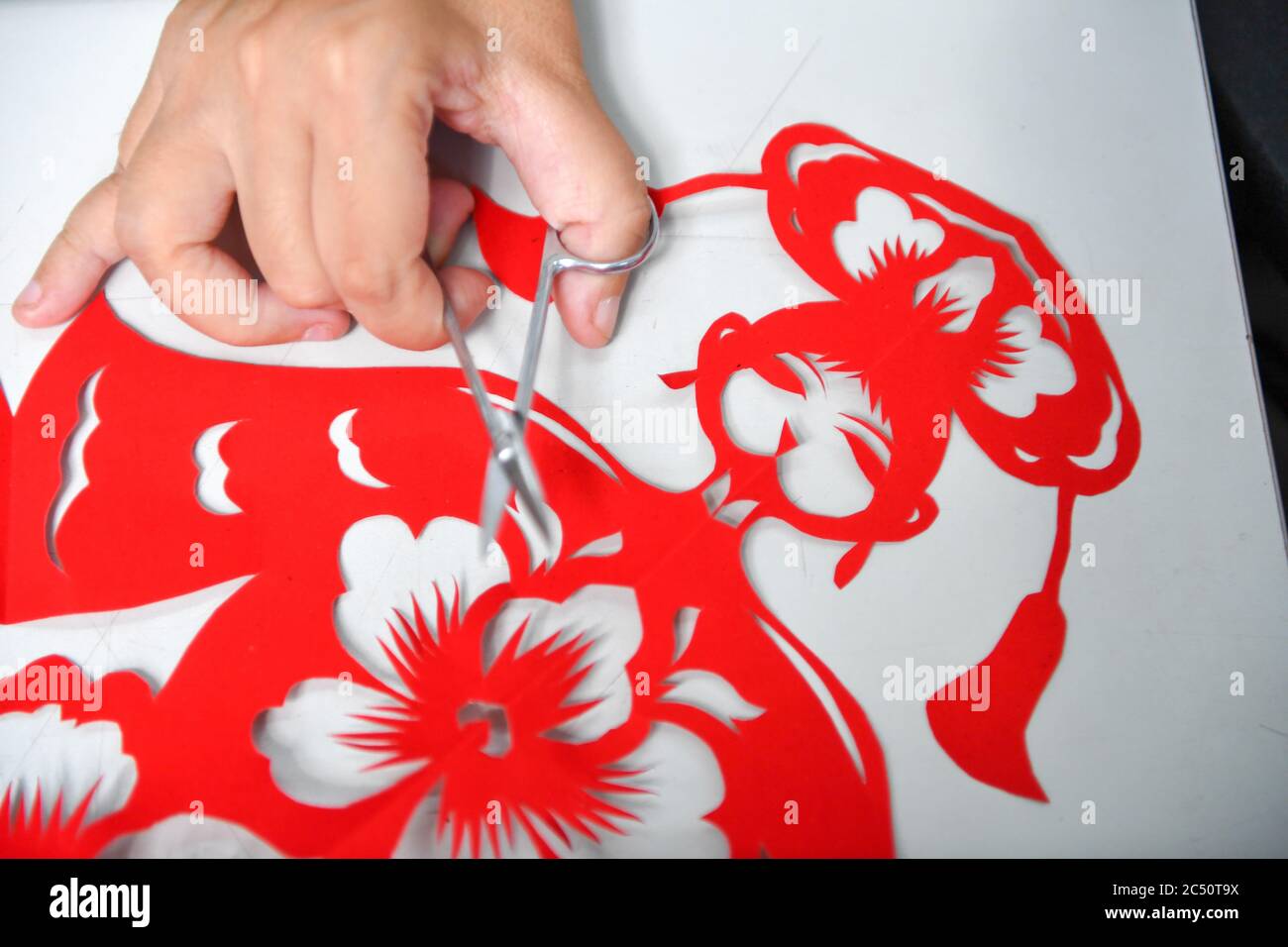 Changchun, China's Jilin Province. 29th June, 2020. Hua Li makes a papercutting work in Jilin City, northeast China's Jilin Province, June 29, 2020. Hua Li became disabled due to illness when she was young. She decided to face up to the hardship and learned papercutting with the help of her family. In order to promote papercutting, Hua and her husband set up a papercutting workshop in Jilin which provides free papercutting training for disabled people. Credit: Zhang Nan/Xinhua/Alamy Live News Stock Photo
