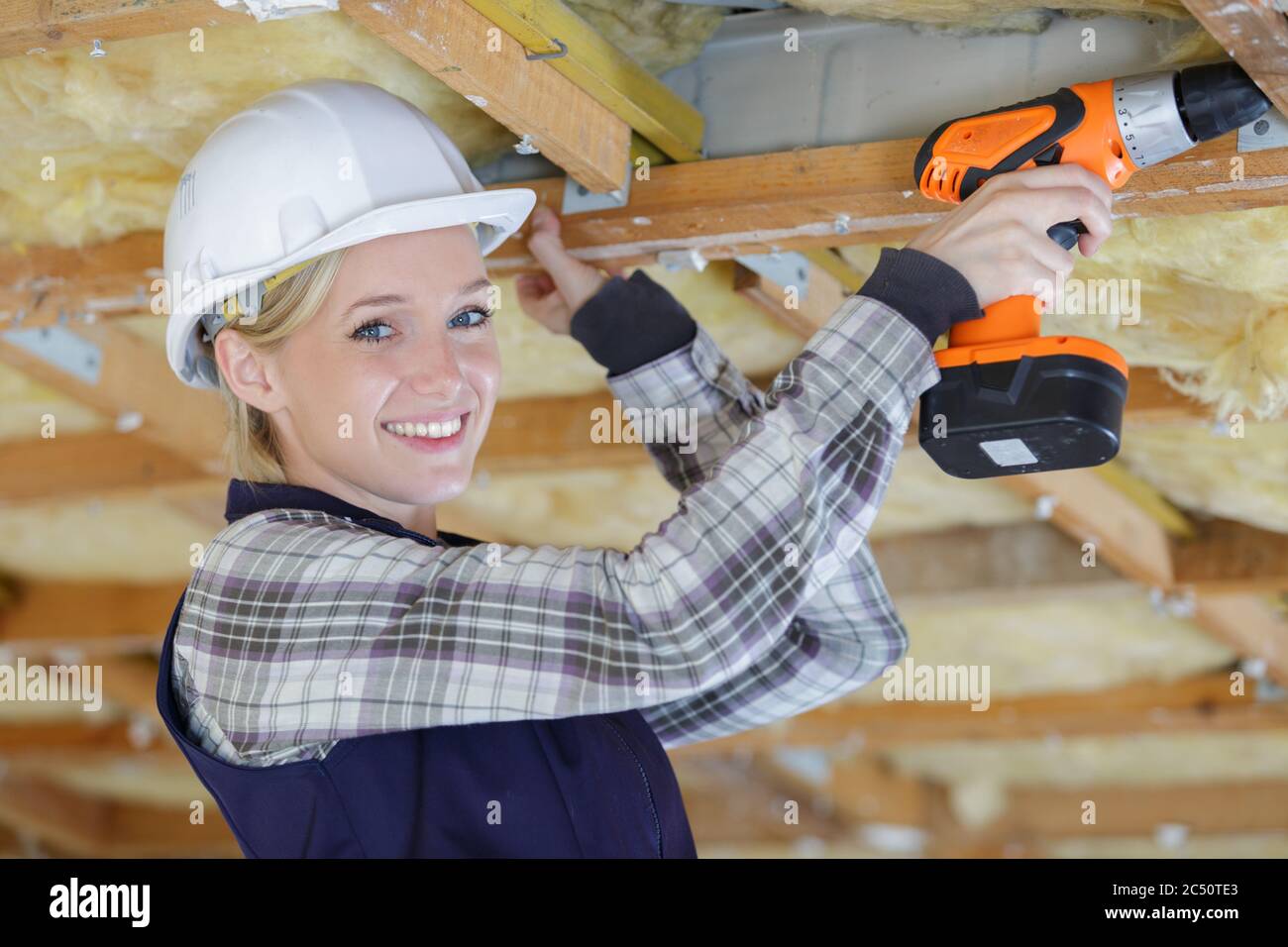 Female Carpenter Drilling Wooden Roof At Construction Site Stock Photo Alamy