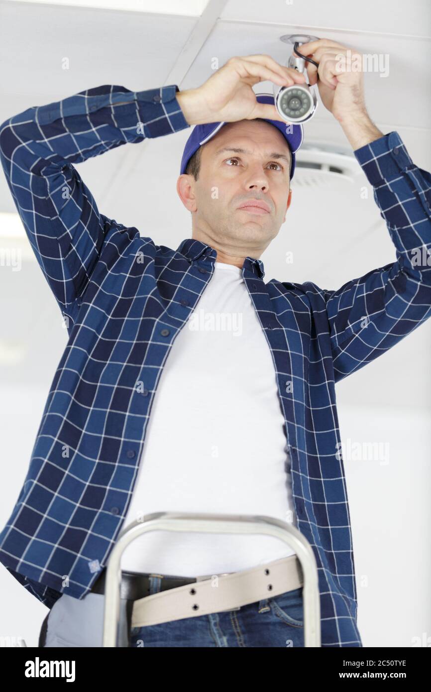 mature contractor installing cctv camera Stock Photo