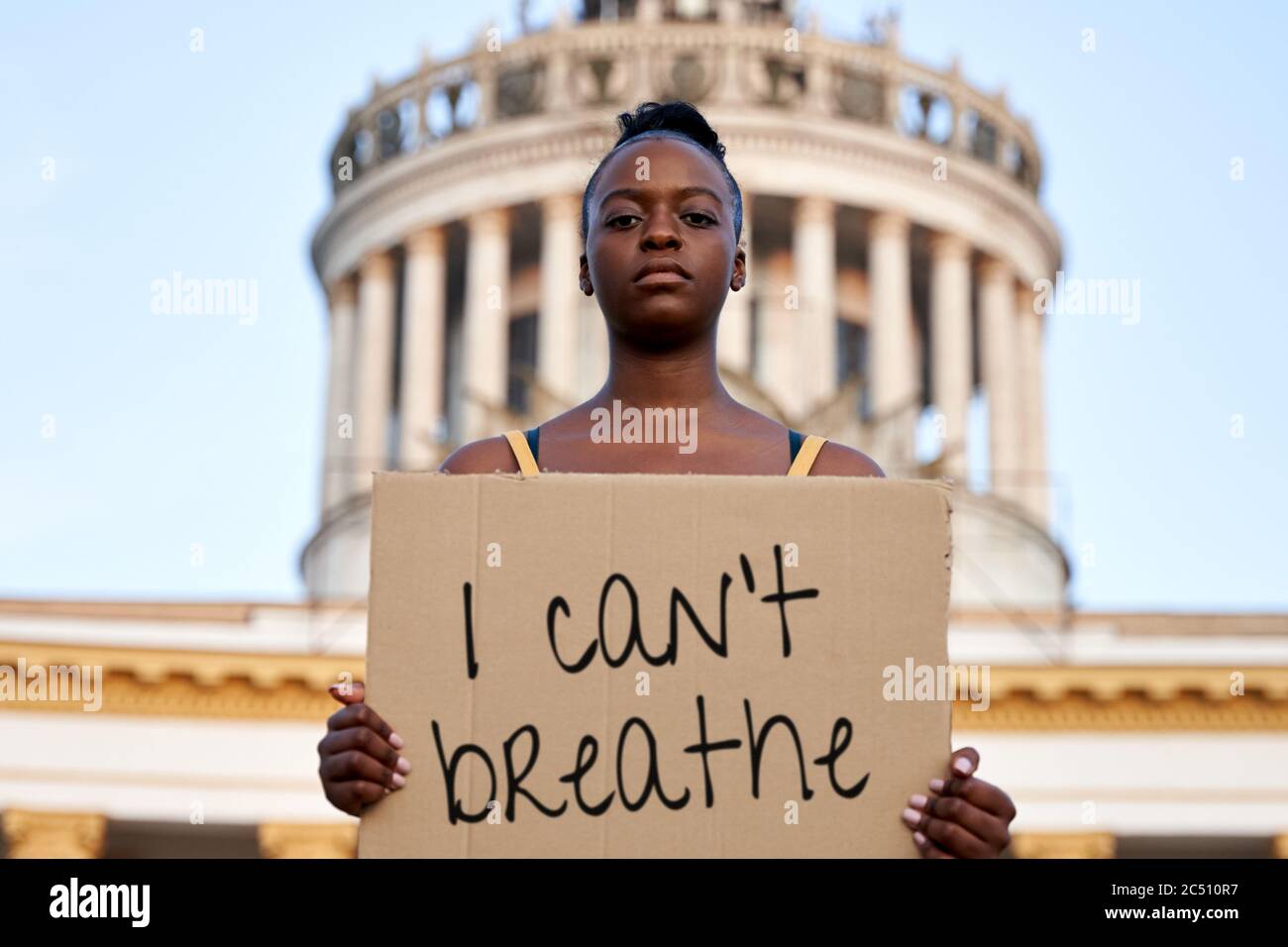 Young african woman activist stand outdoor hold empty sign protesting on street. Stock Photo