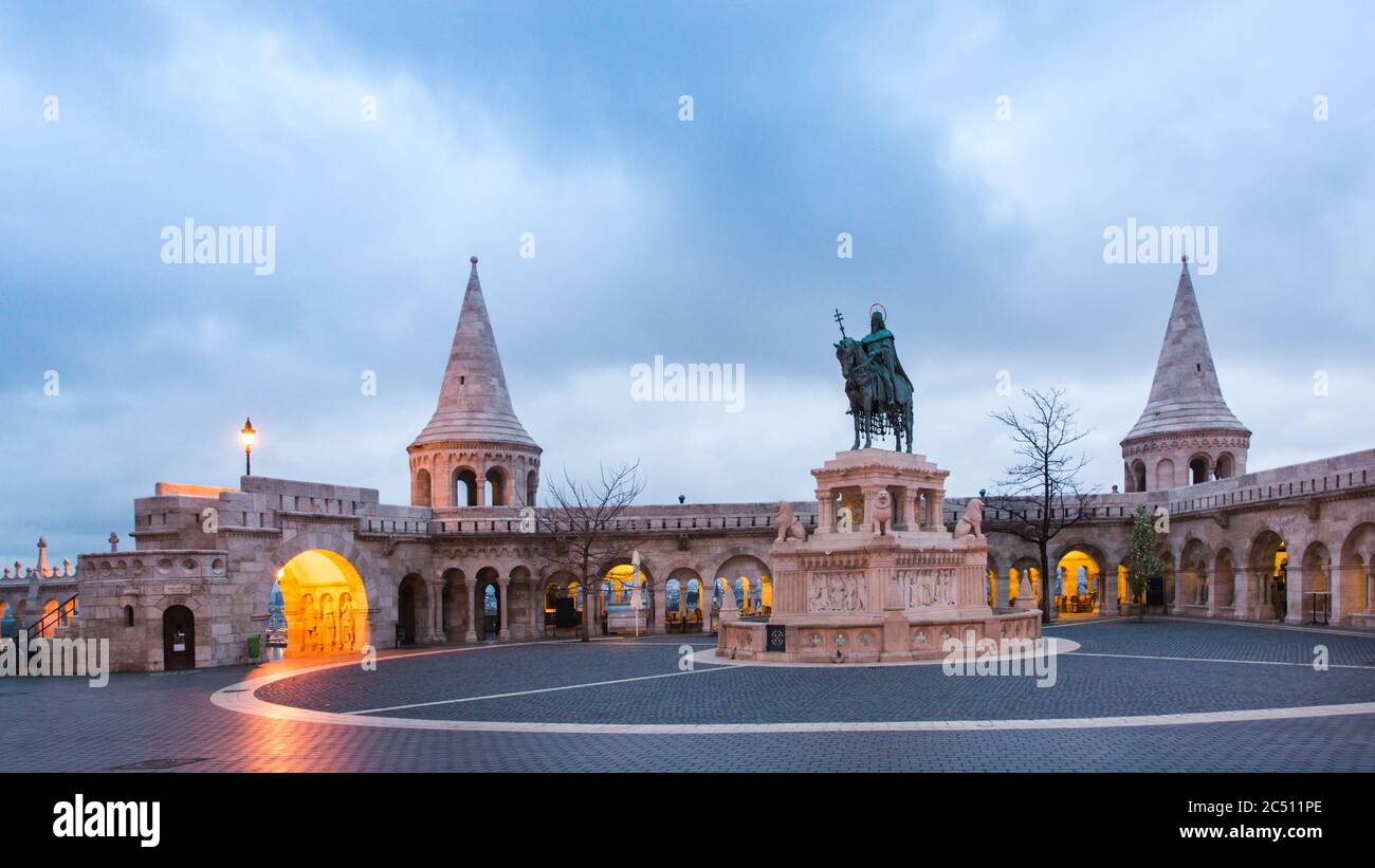 Catholic Matthias Church and Statue of Saint Stephen on Fishermans Bastion in Budapest, Hungary on sunrise with light from lanterns Stock Photo