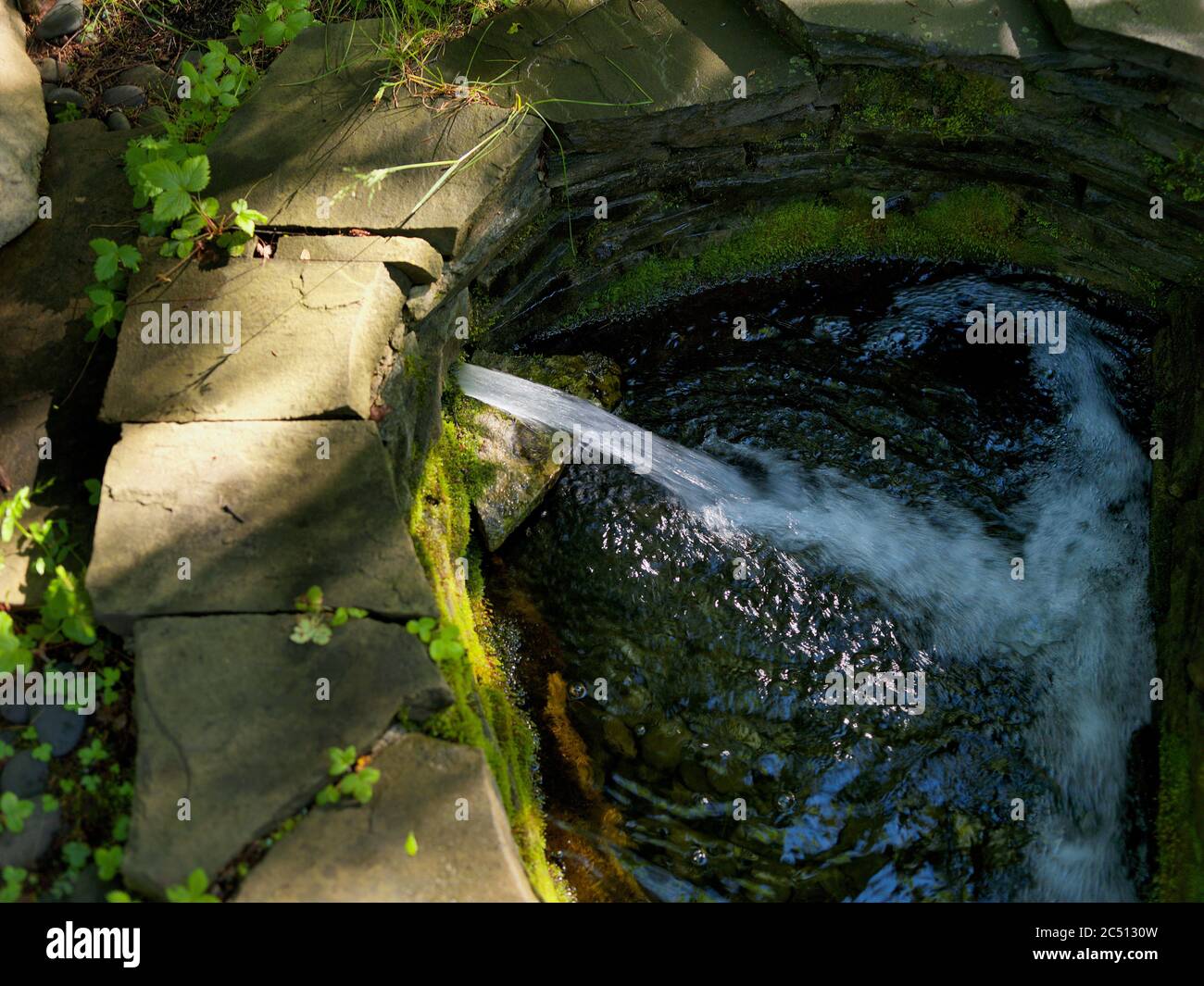 artificial waterfall filling a pond, outdoor summertime  shot Stock Photo