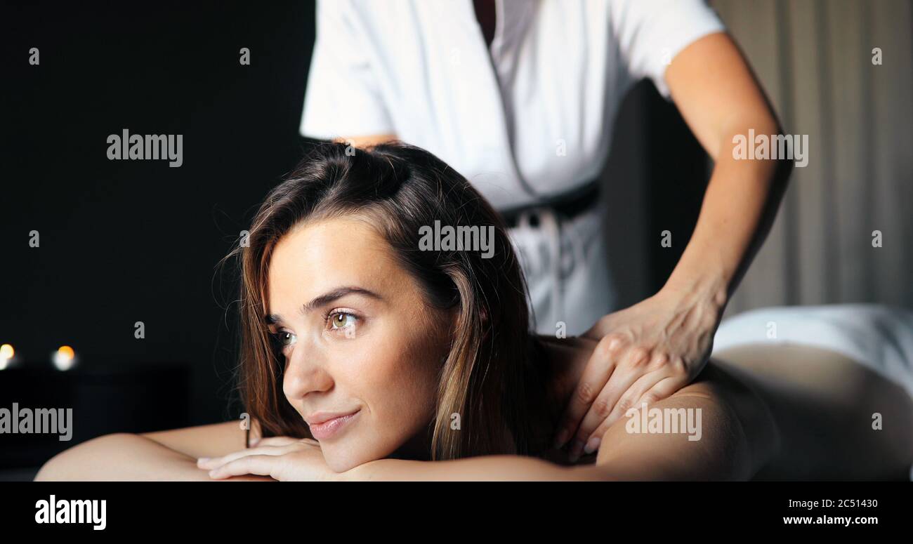 Masseur doing massage on woman body in the spa salon. Beauty treatment concept. Stock Photo