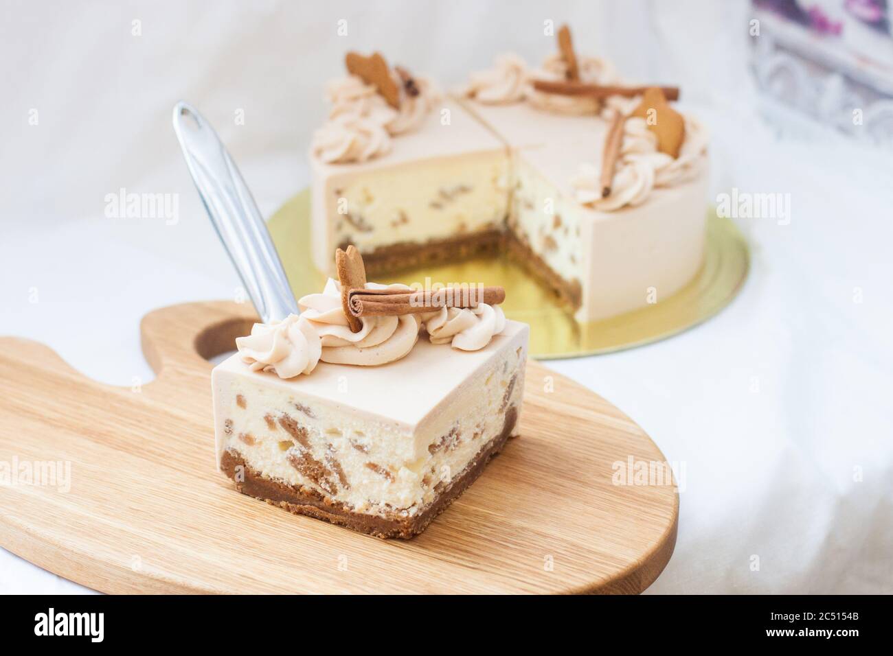 Slice of caramel cheesecake with whipped cream, cookies, gingerbread