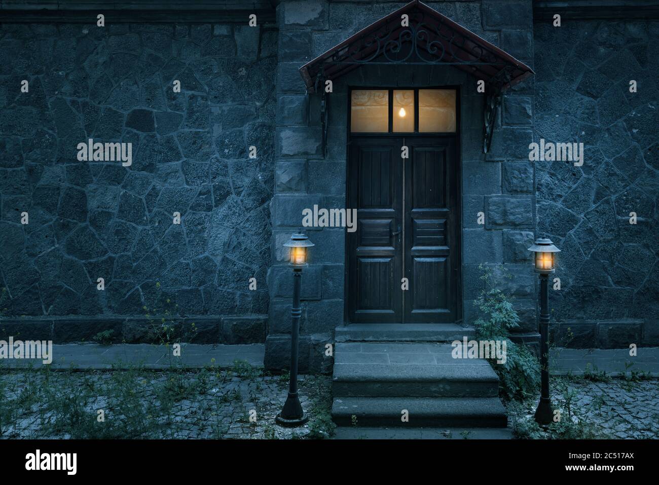 Old rustic classical stone house and brown vintage wooden door with wrought iron. High quality photo Stock Photo