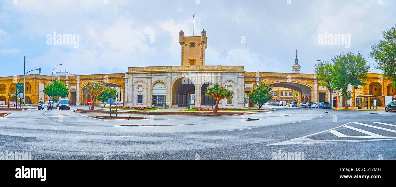 Panorama of Earthen Gate (Puertas de Tierra) with tall tower, arched passes and flower beds, Cadiz, Spain Stock Photo