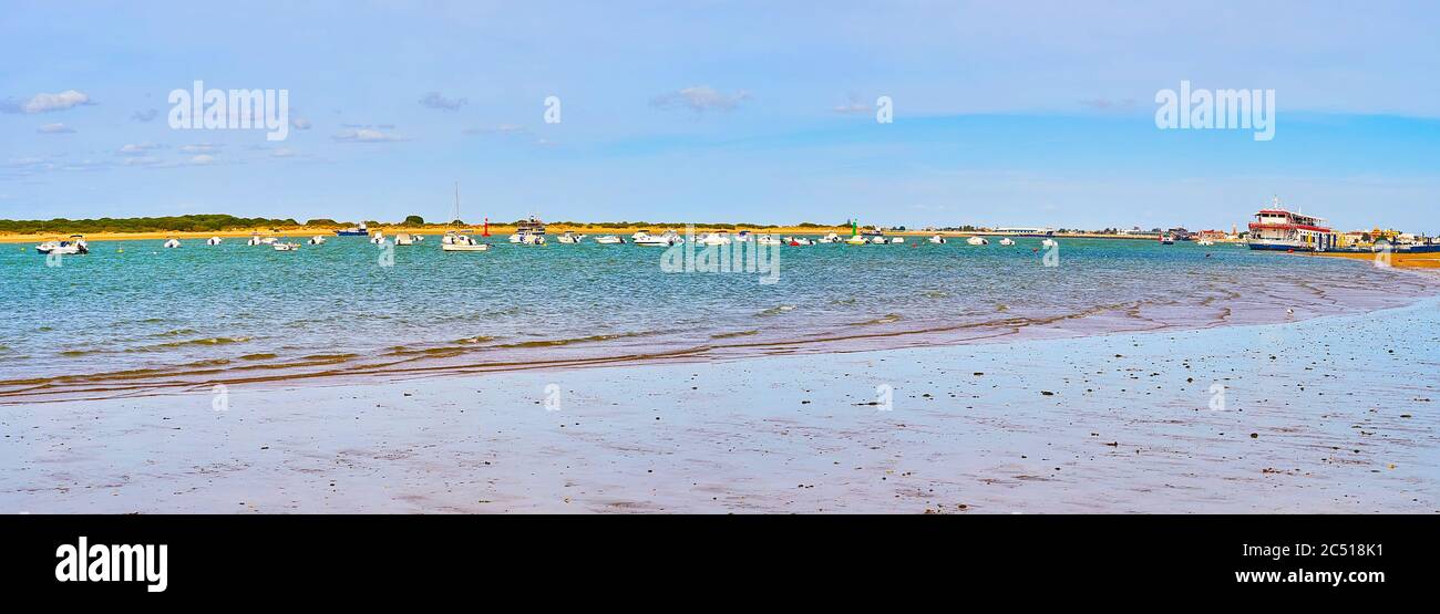 Panorama of Calzada beach with many moored boats, rocking on waters of Guadalquivir river, Sanlucar, Spain Stock Photo