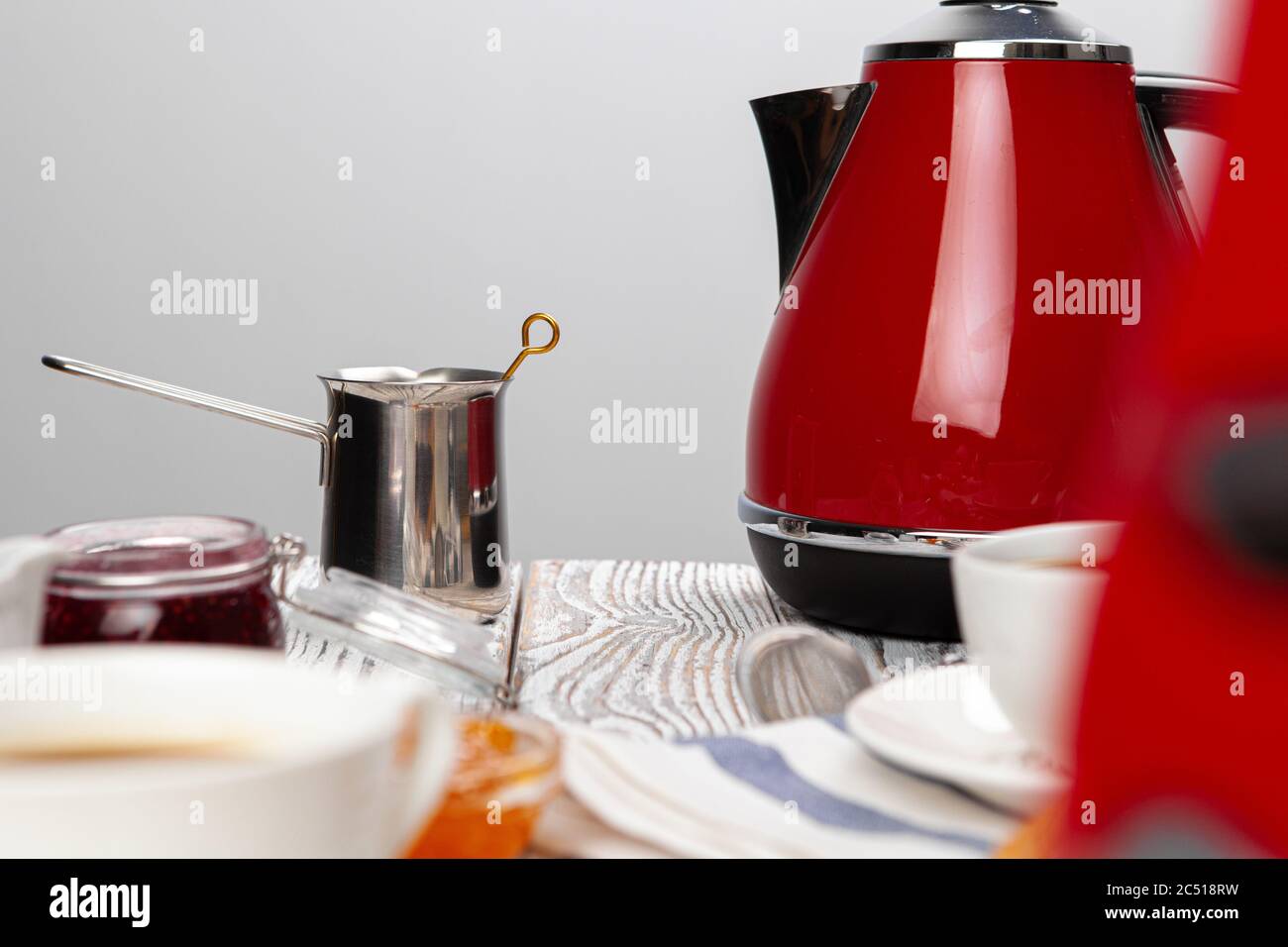 Modern electric kettle and cups of tea on white wooden table in kitchen.  Space for text Stock Photo by ©NewAfrica 317399329