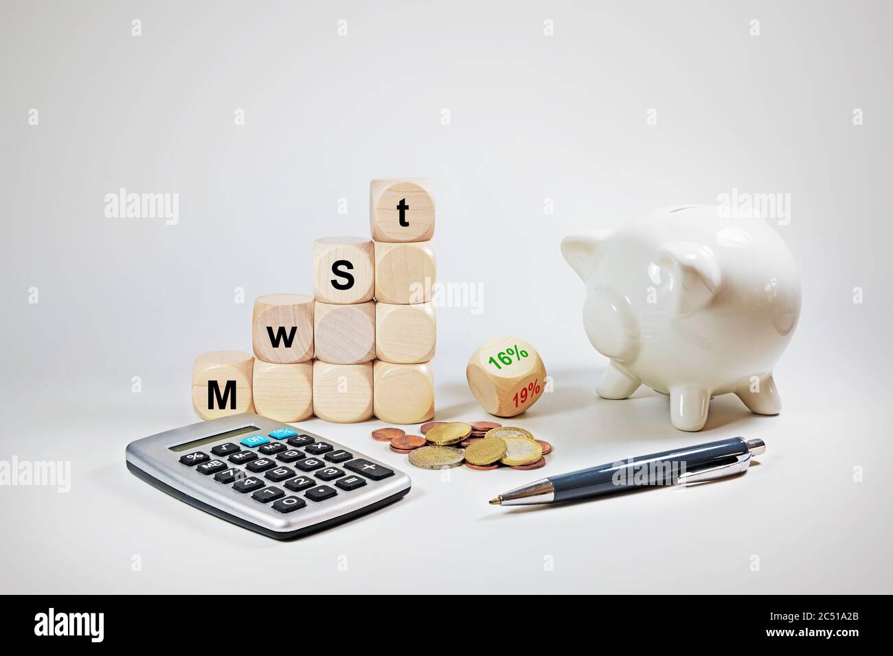 Calculator, piggy bank and dices with German text MwSt (value added tax), reduction from 19% to 16%, economic stimulus package in the coronavirus cris Stock Photo