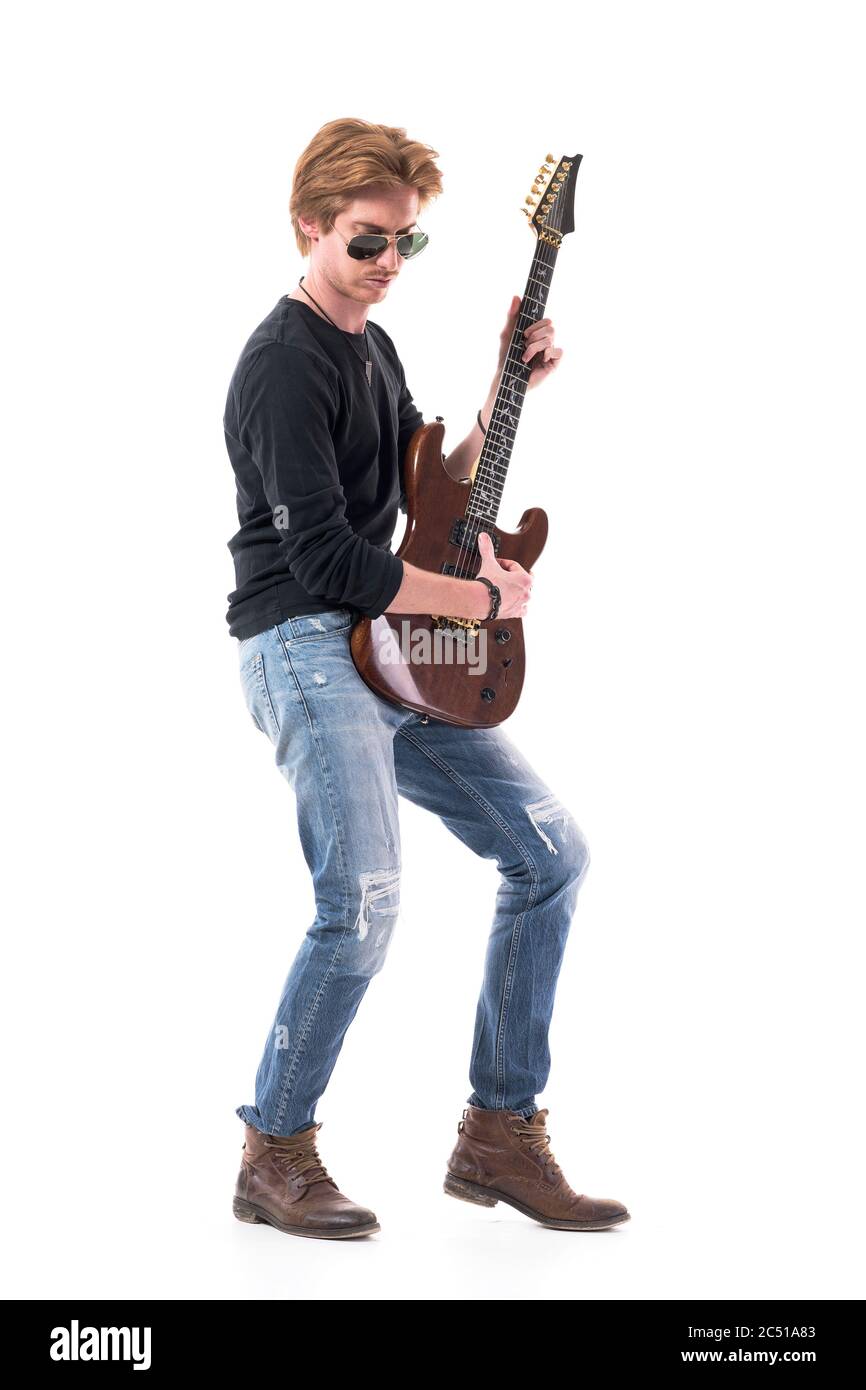 Side view of red hair rocker playing electric guitar with sunglasses ...