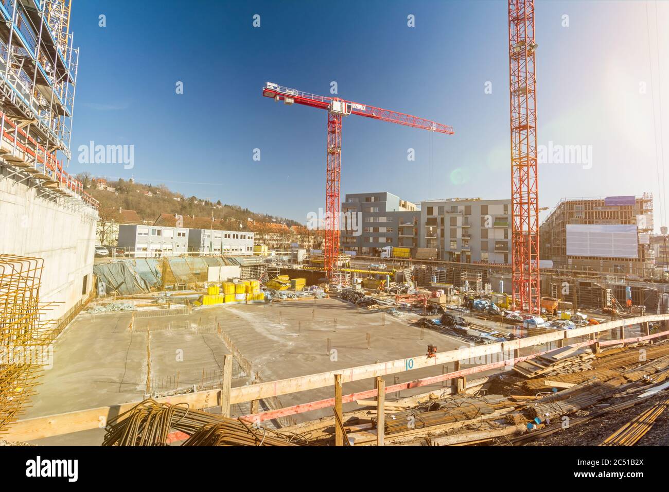 Large building site with foundations and cranes and scenic lens flare Stock Photo