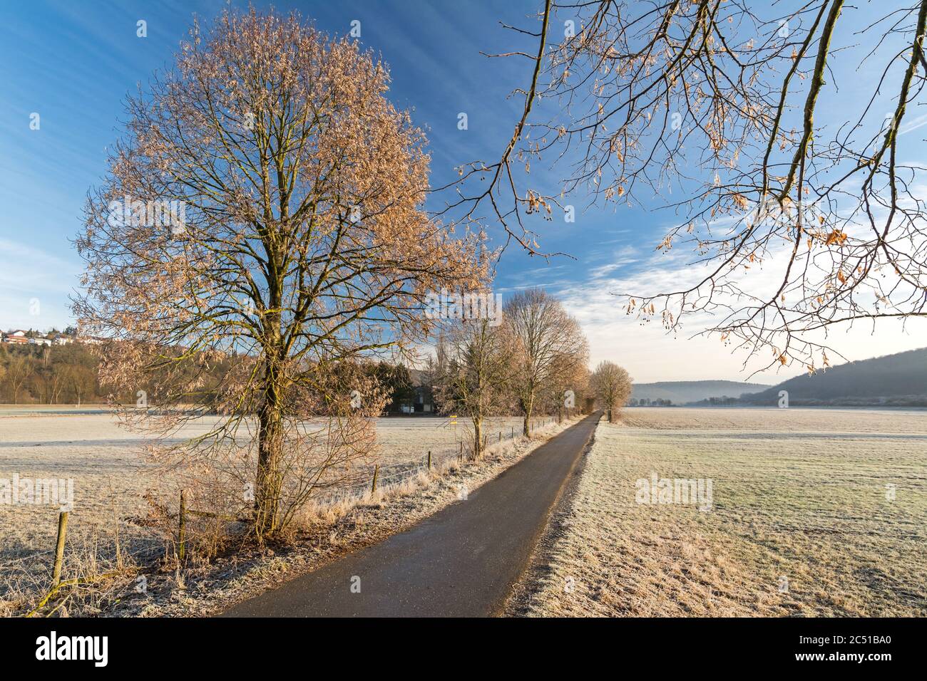 Scenic rural autumn landscape with foot path and fields covered with frost Stock Photo