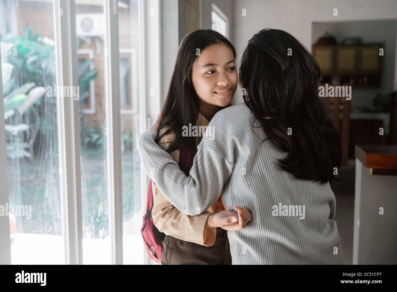 mother embrace daughter before leaving to school in the morning Stock Photo