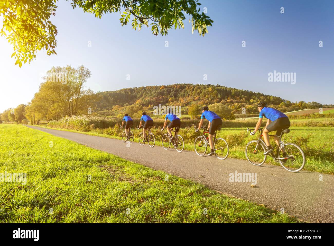 Multiple image of man on a racing bike in scenic autumn landscape Stock Photo